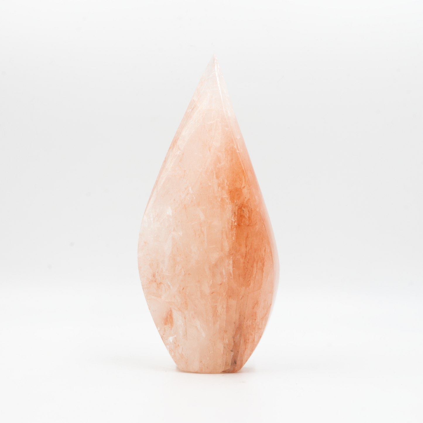 Polished hematoid quartz flame sculpture with soft peach and russet inclusions. Hand-carved into an elegant teardrop form with natural sheen.