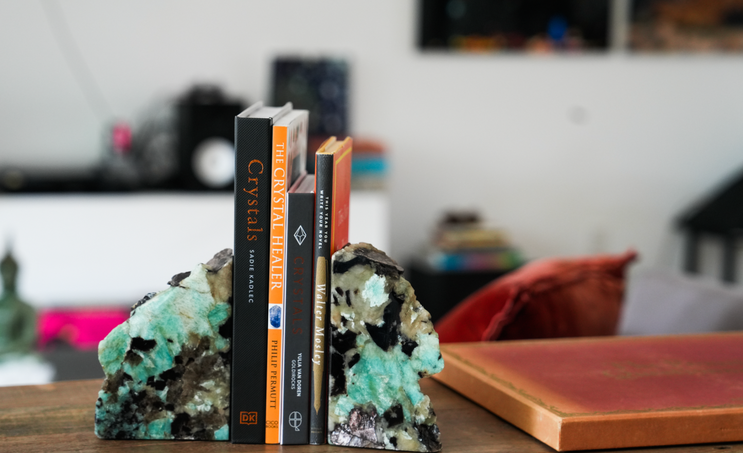 Amazonite and black tourmaline bookends with crystal books between them in lifestyle living room setting