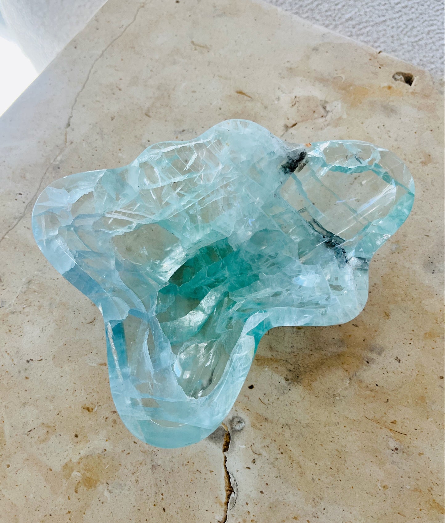Small green fluorite bowl on marble table