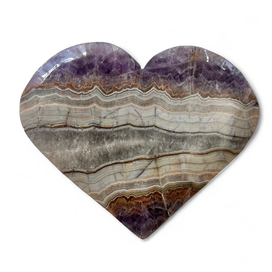 Heart-shaped stone with layered patterns on a white background