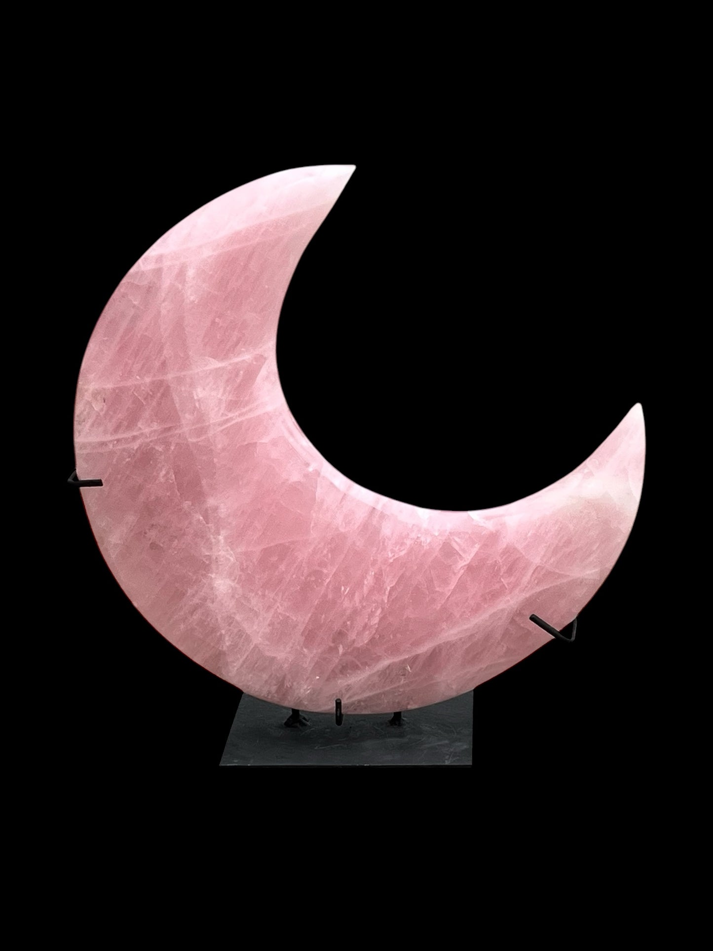 Pink Rose Quartz moon on black stand with black background