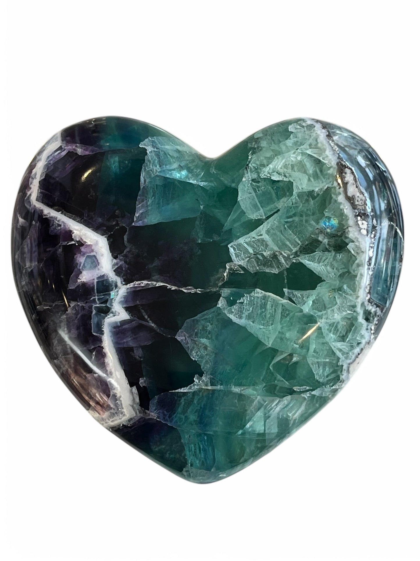 A polished heart-shaped fluorite crystal with a mix of green, blue, and purple colors.