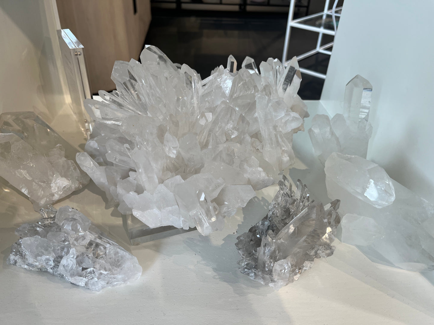 Multiple clear quartz clusters and points near a natural Arkansas quartz cluster formation