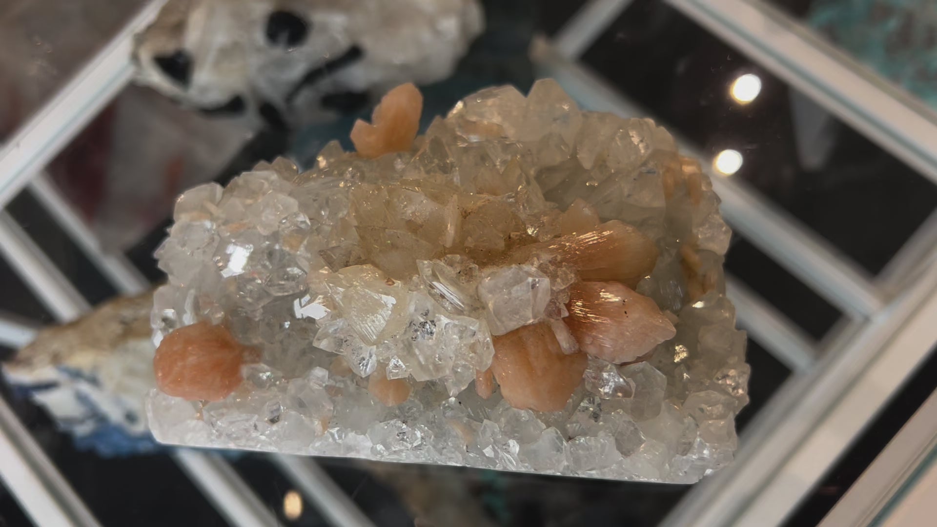 Video of Apophyllite crystal cluster on blue chalcedony with peach stilbite blades, showcasing translucent sparkle and soft pastel mineral formations.