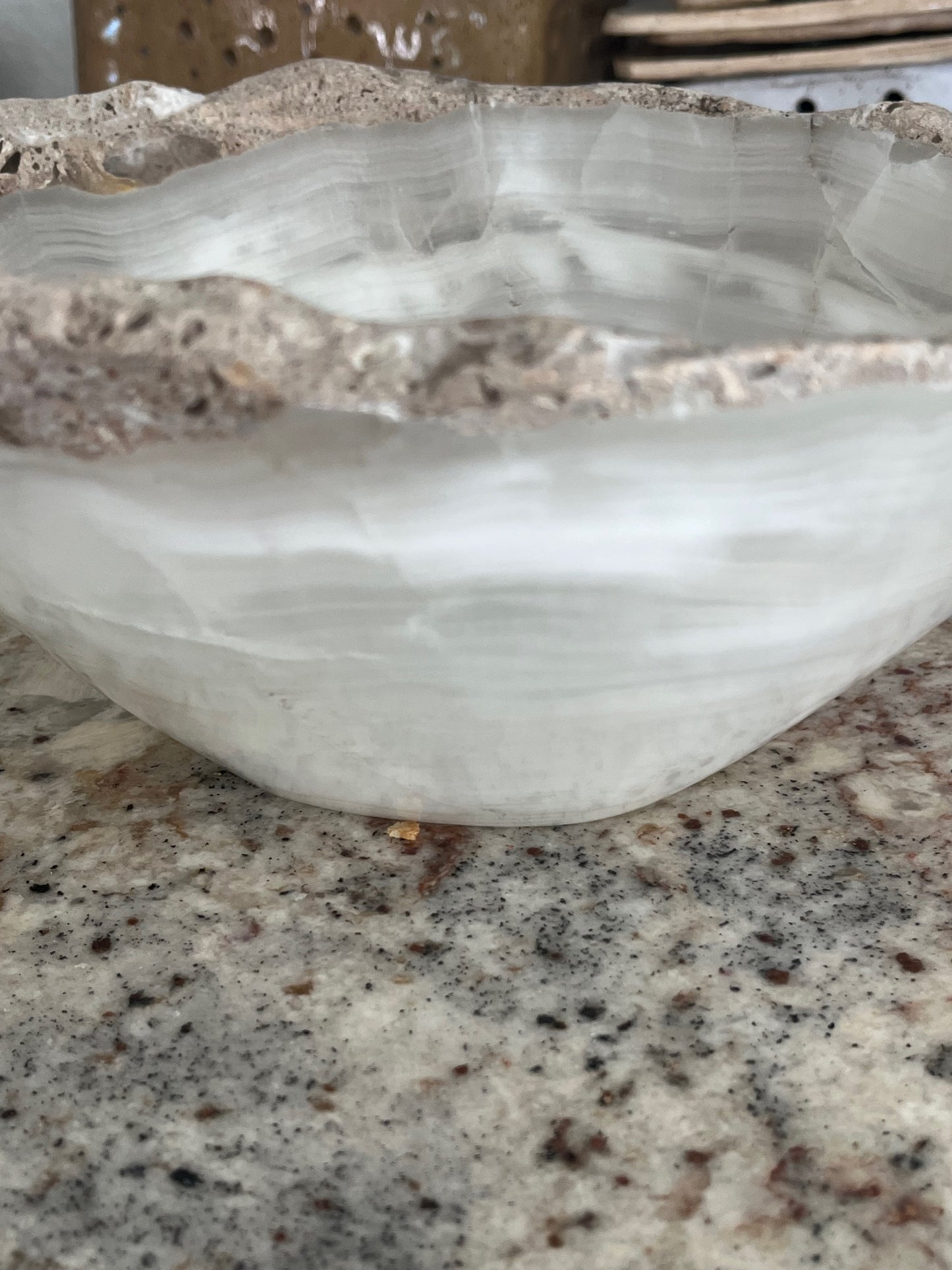 Side view of white onyx bowl highlighting natural stone rim texture