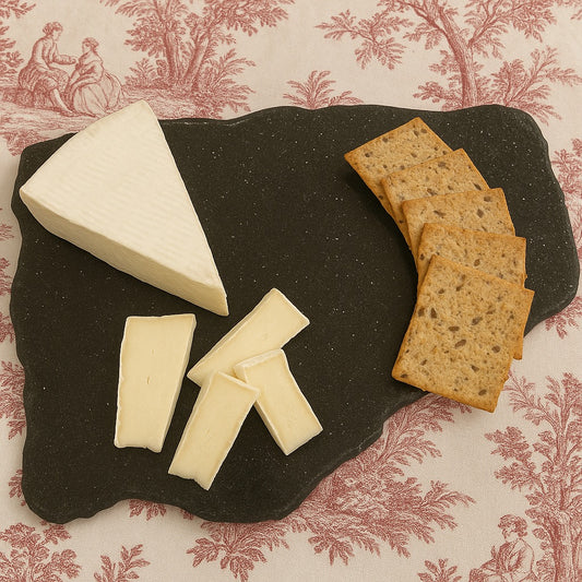 Specularite charcuterie board styled with cheese and crackers on patterned linen