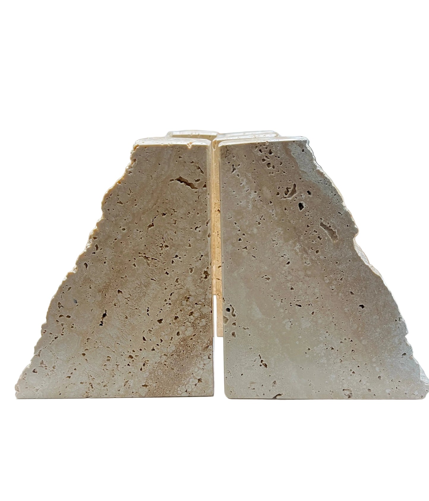 Pair of natural travertine stone bookends with organic edges and visible texture on work surface