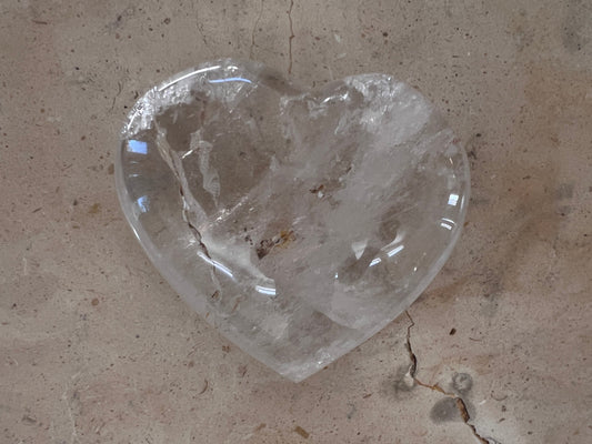 Clear crystal heart-shaped object on a textured surface