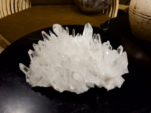 natural arkansas clear quartz cluster on black table