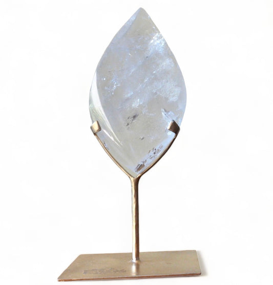 A clear quartz double pointed flame on a bronze stand.