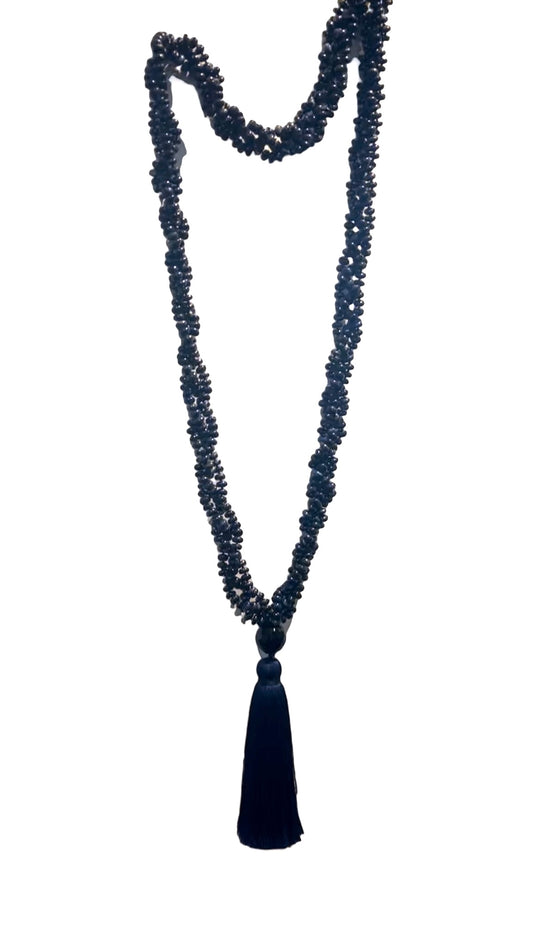 Long lapis lazuli mala necklace with dark blue gemstone beads and a black tassel, designed for wall decor.