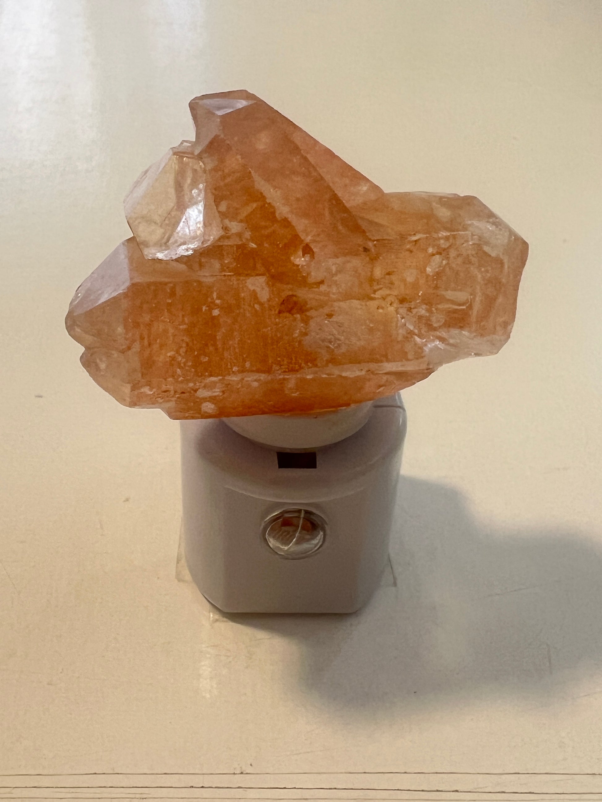 Crystal night light with a tangerine quartz on a white background