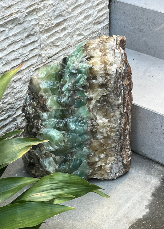Decorative crystal with green and white hues on a stone surface