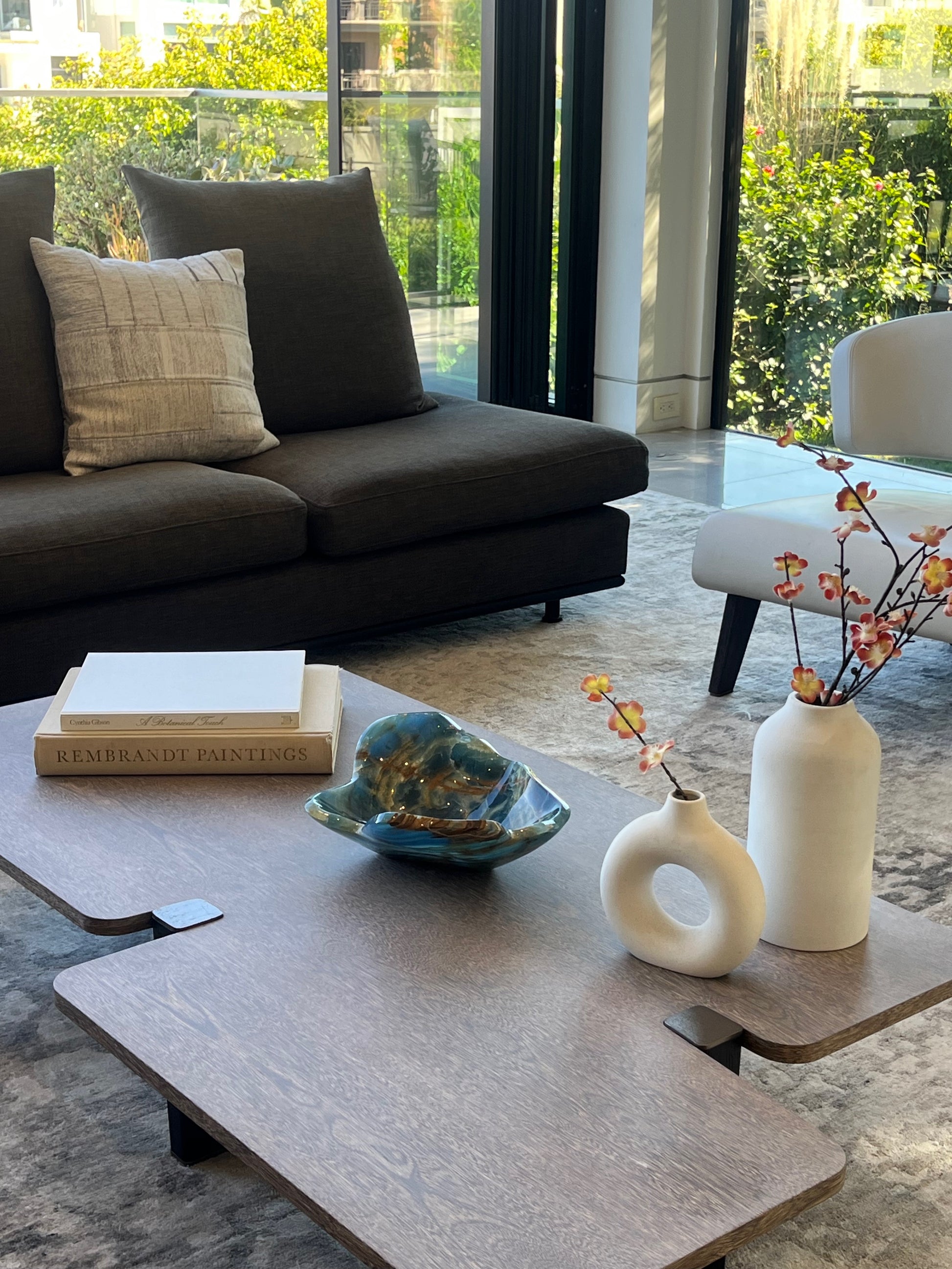 Modern living room with a dark sofa, coffee table, and decorative items, including a blue calcite bowl.