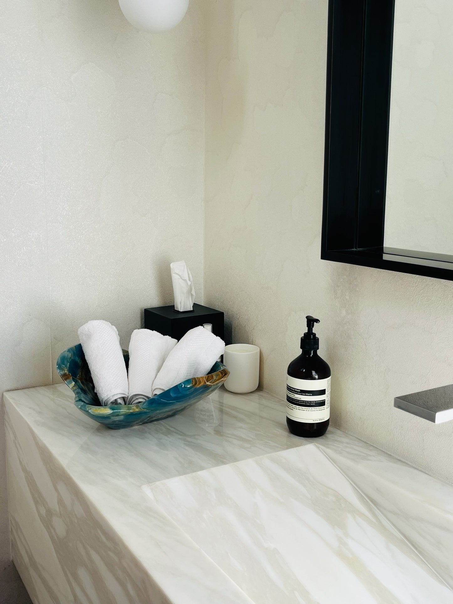 Bathroom counter with soap dispenser, mirror, and blue bowl with handtowels, .