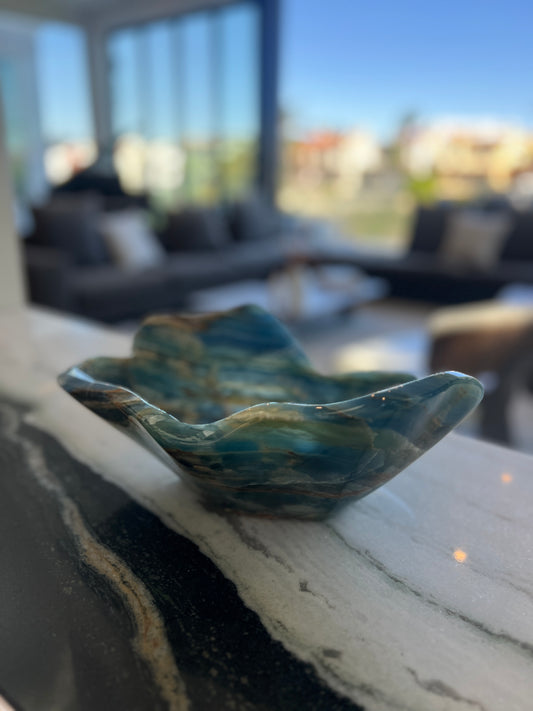 Marbled blue and green dish on a surface with a blurred indoor background