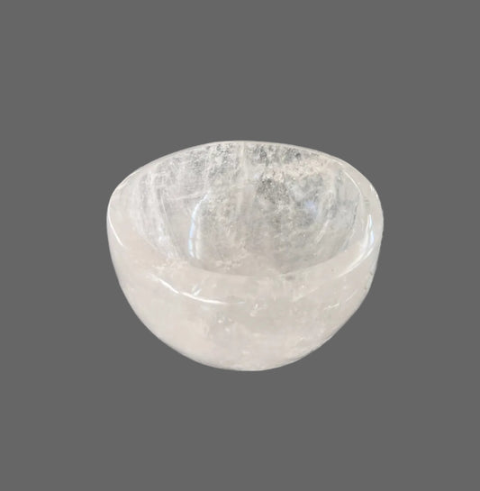 White quartz bowl on a black marble table with a book in the background