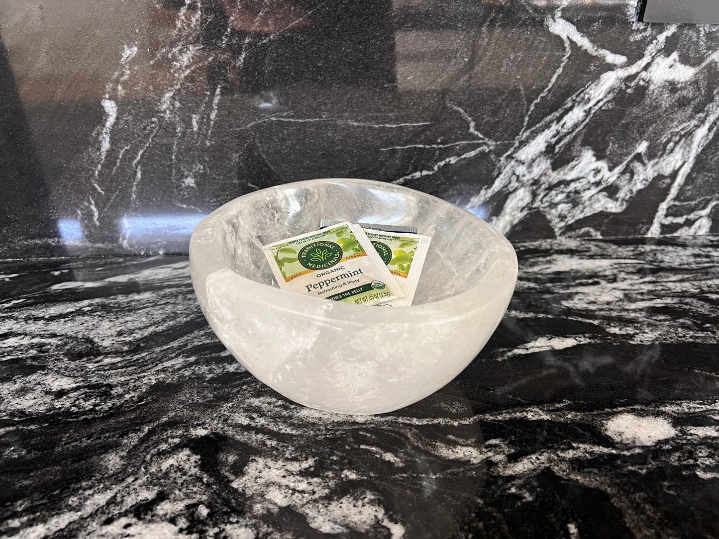 Clear Quartz bowl with tea bags on a marble surface