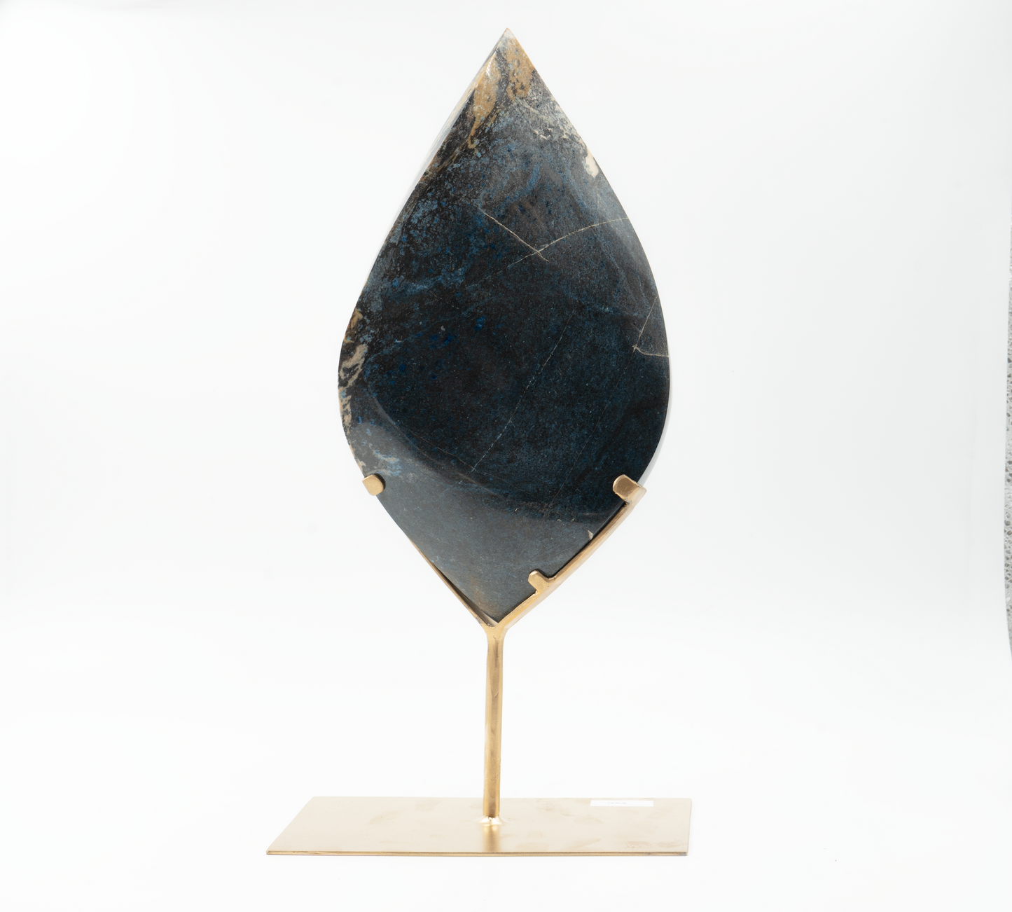 A teardrop-shaped Trolleite mineral on a stand against a white background.