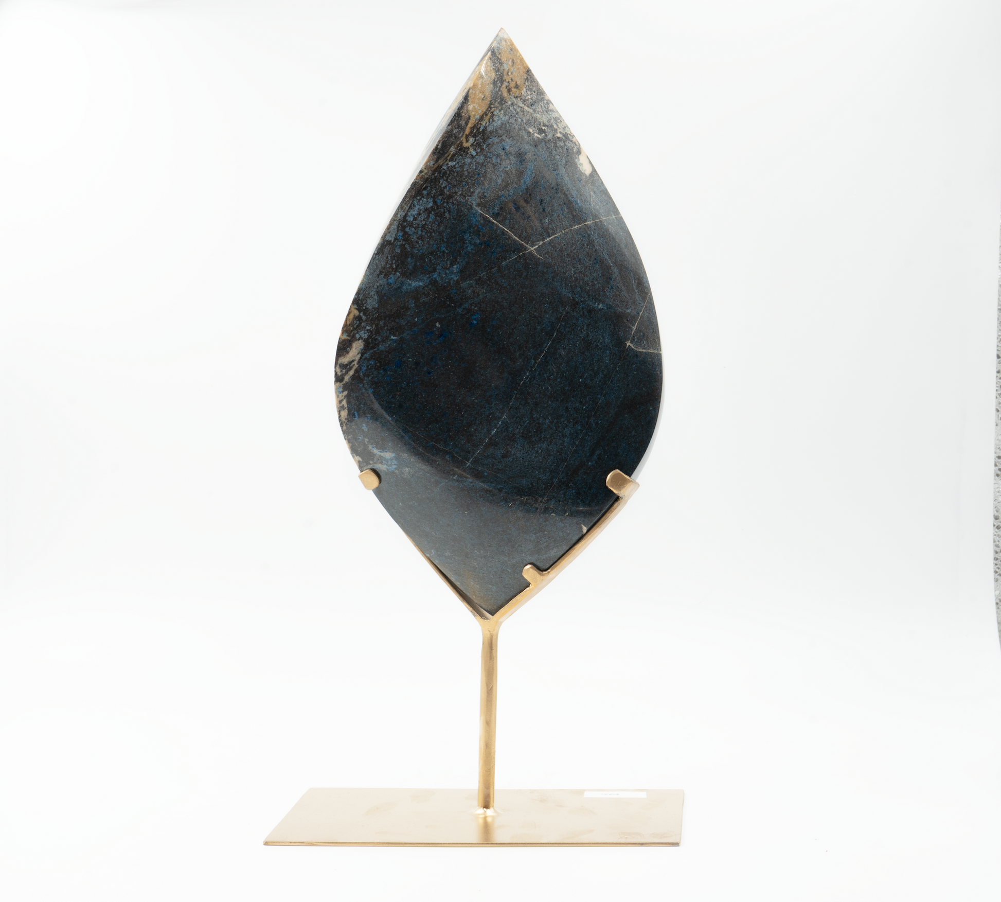 A teardrop-shaped Trolleite mineral on a stand against a white background.