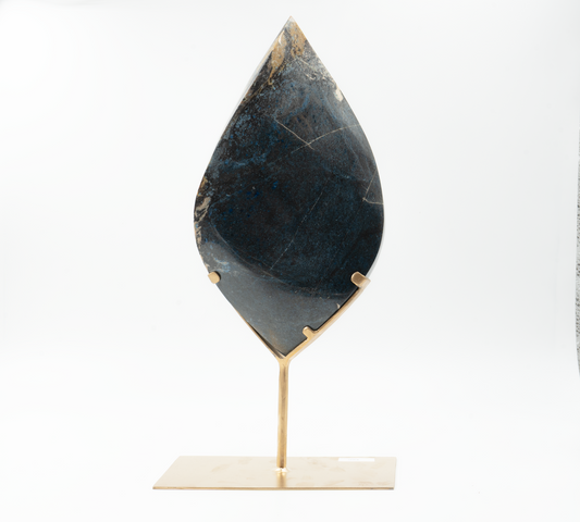 A teardrop-shaped Trolleite mineral on a stand against a white background.
