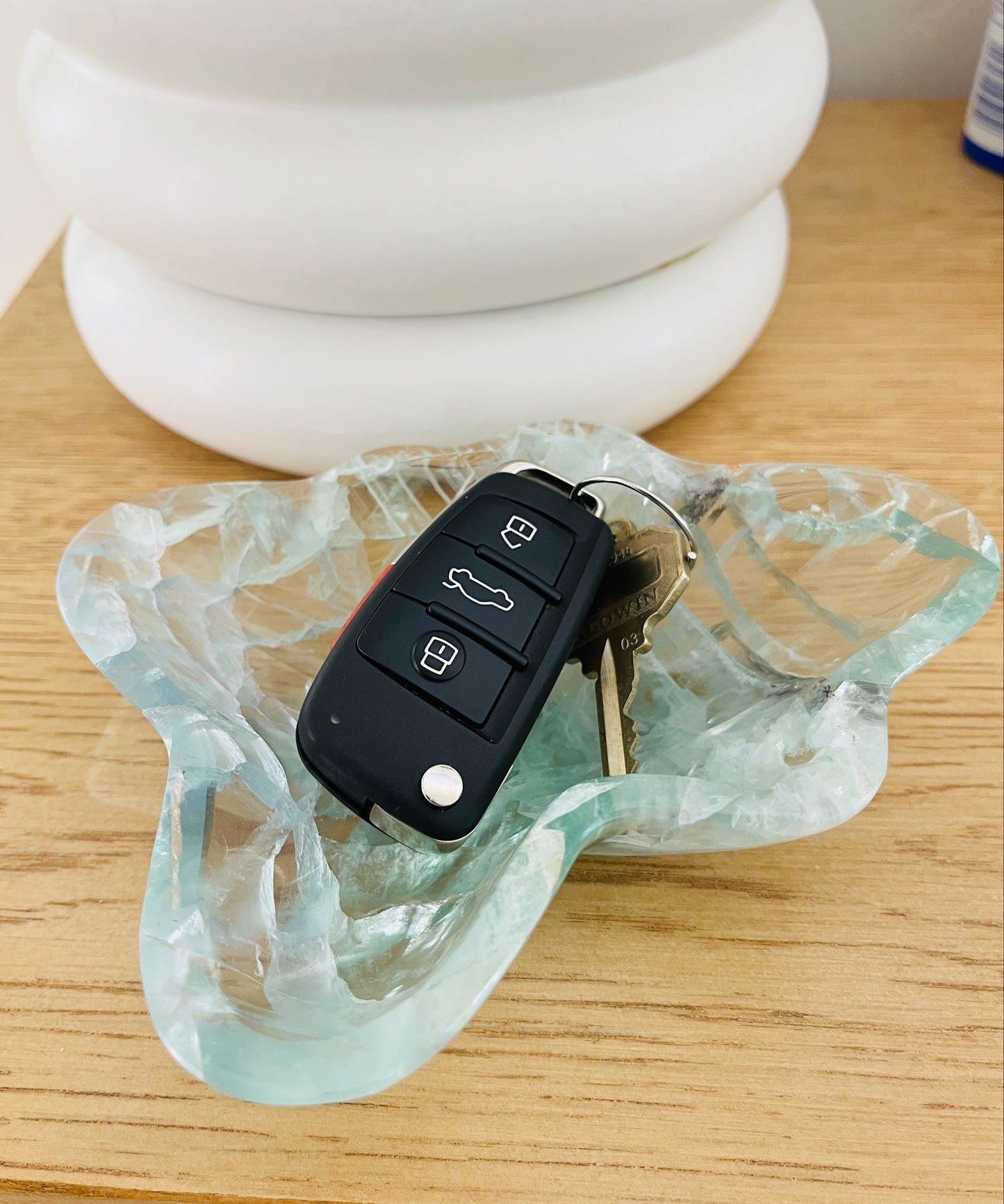 Pale green dish with keys on a wooden surface