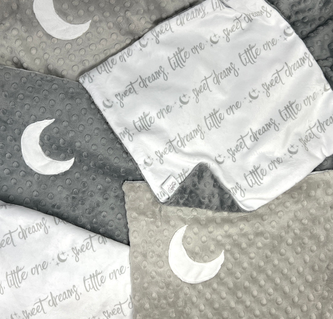 Gray and white baby blankets with moon designs and 'sweet dreams little one' text.