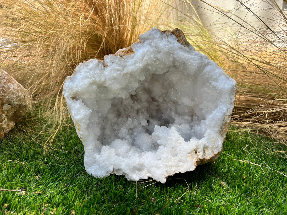 Geode crystal on grass with dry grass in the background