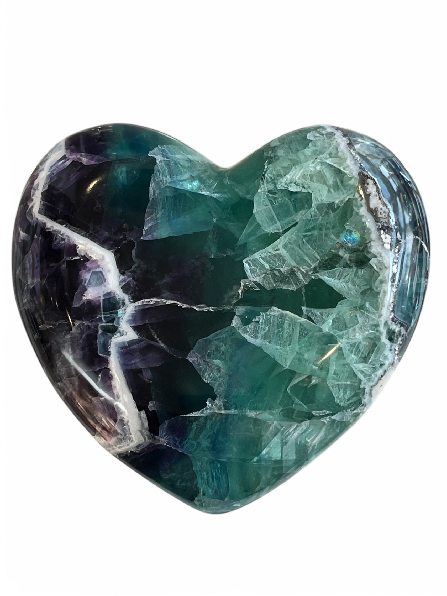 A polished heart-shaped fluorite crystal with a mix of green, blue, and purple colors.