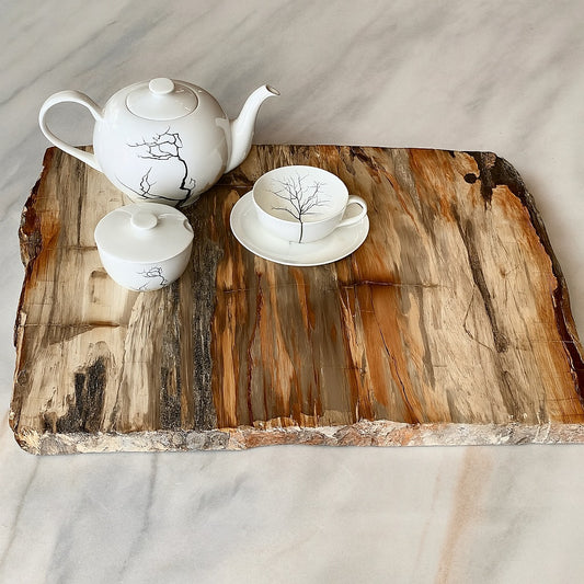 XL square petrified wood platter with raw edge detailing, showcasing natural grain in warm earth tones. Styled with a white ceramic tea set atop marble.