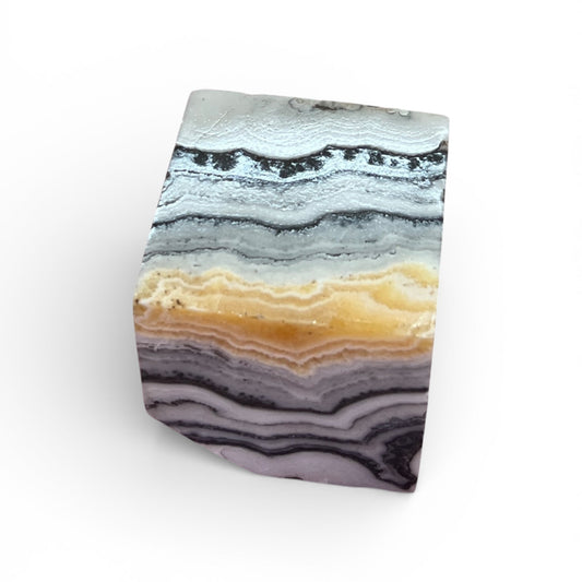 Phantom zebra calcite cube with light horizontal banding and translucent stone texture