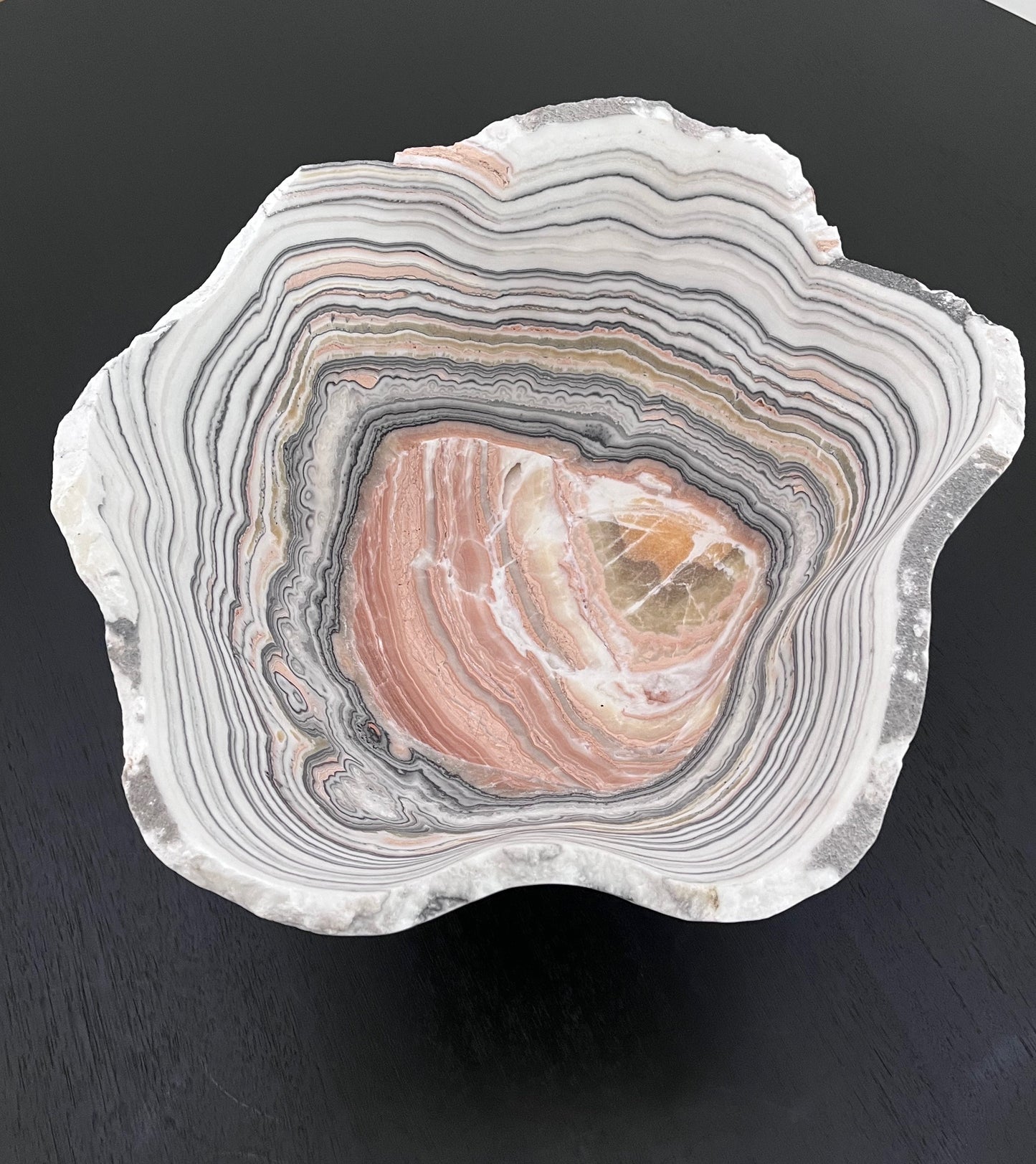Decorative stone with concentric layers on a dark surface