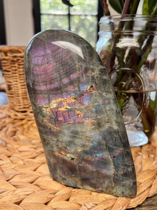 purple labradorite polished on table near flower vase
