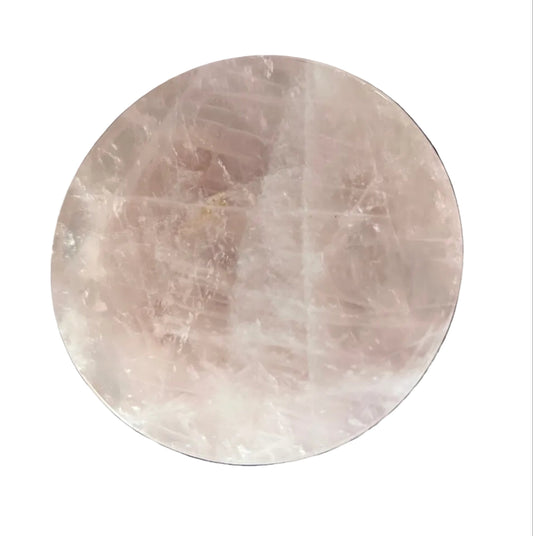 Round rose quartz coaster on a dark granite surface