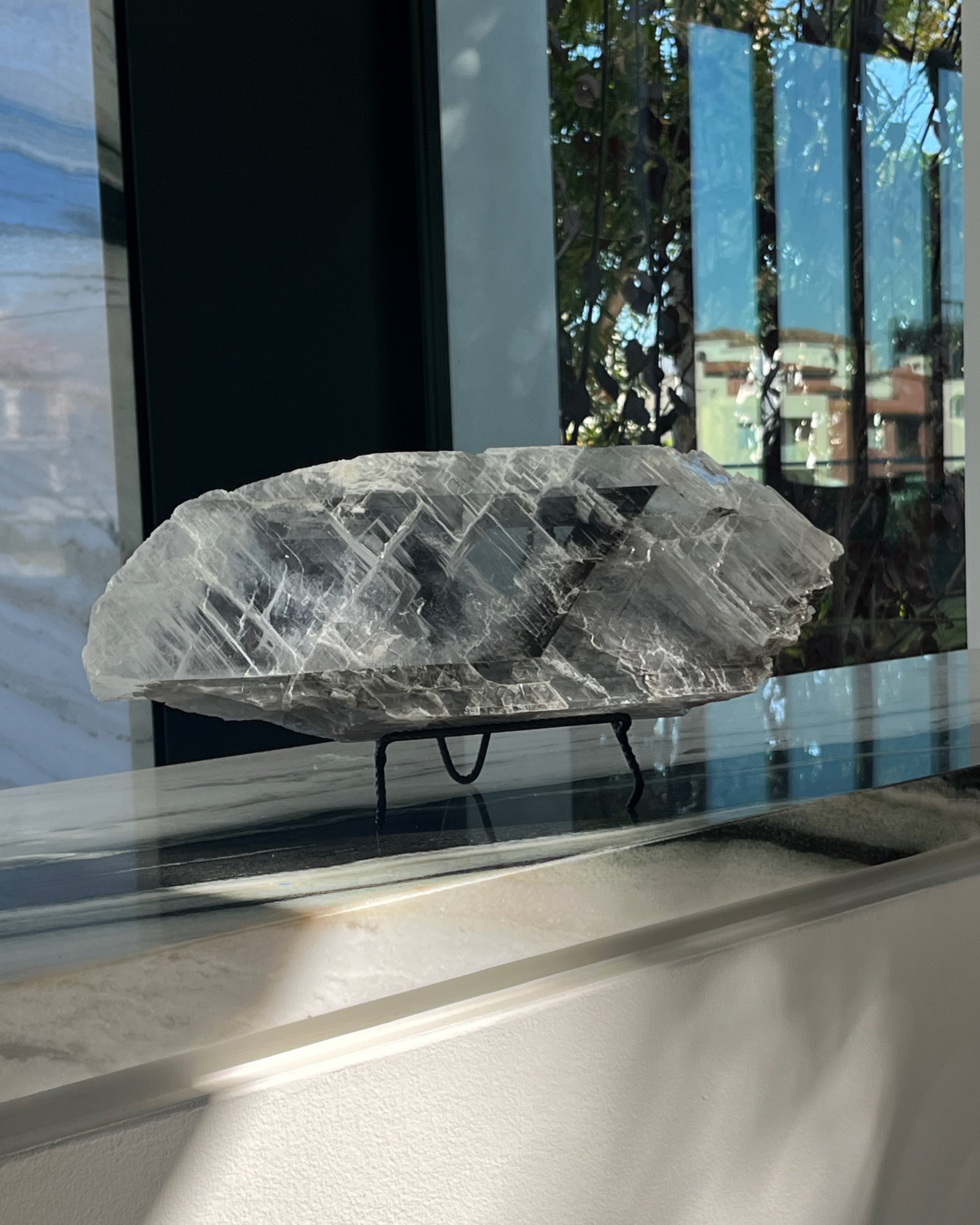 Crystal Selenite plate on a stand in front of a reflective surface