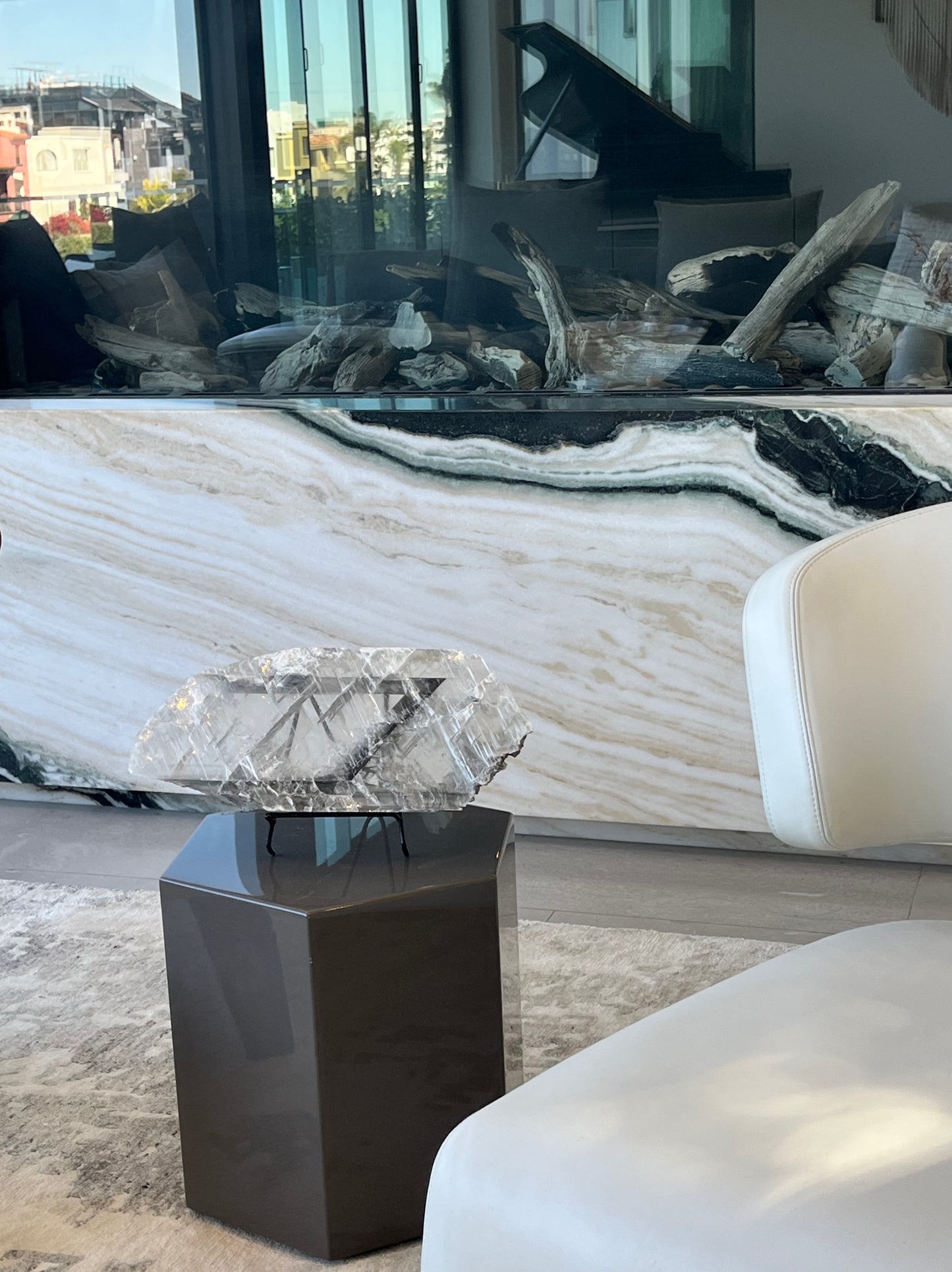 Decorative crystal on a stand in front of a modern fireplace with large glass panels.