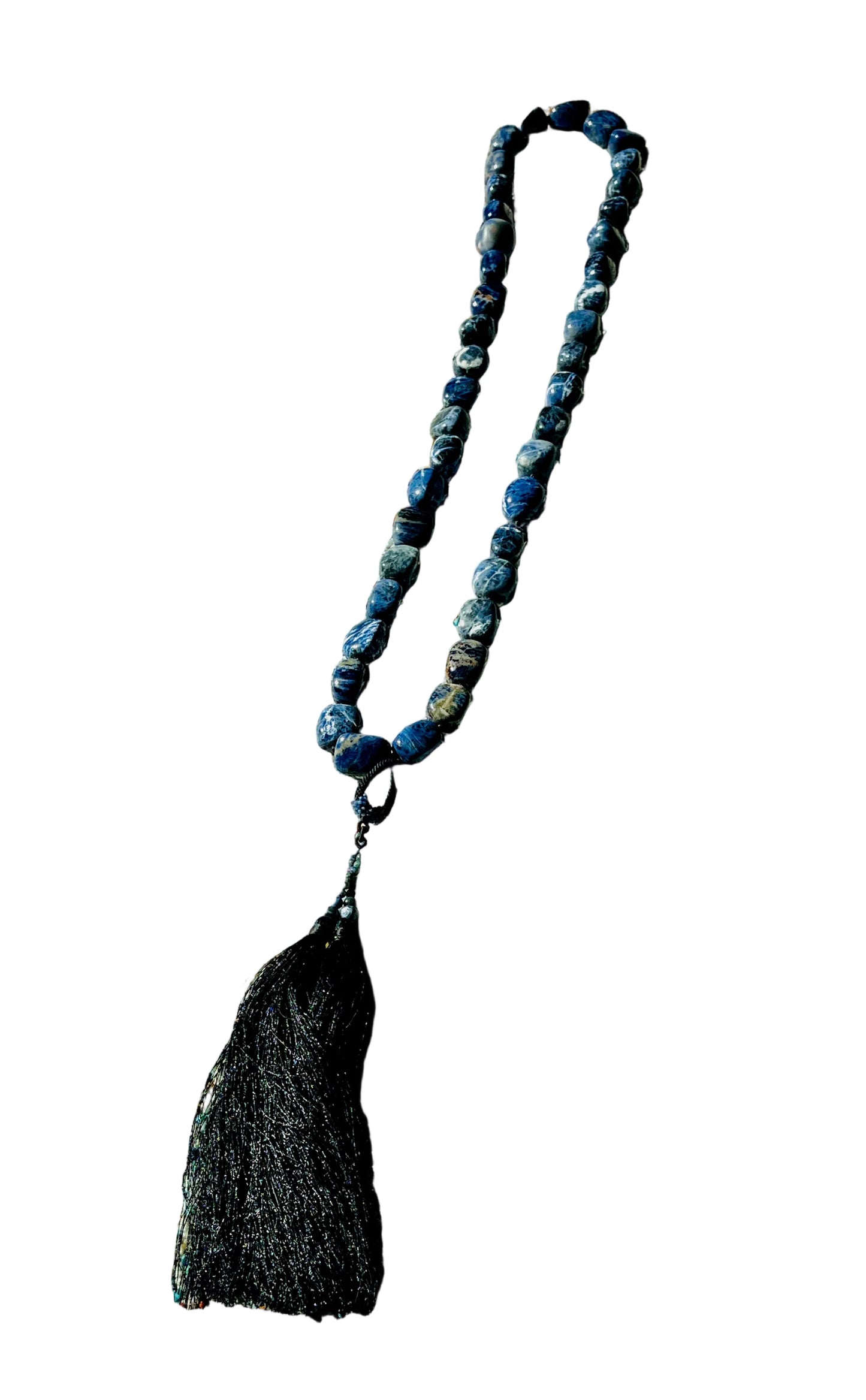 Blue beaded necklace with a tassel on a textured fabric background