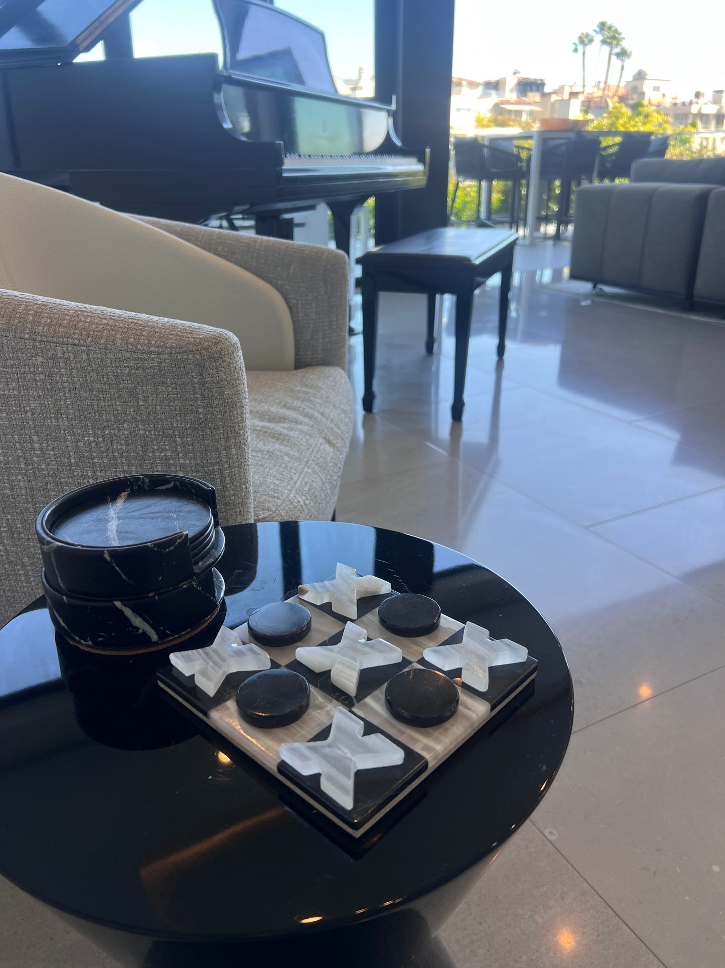 Living room with a black coffee table featuring decorative items, a piano in the background.
