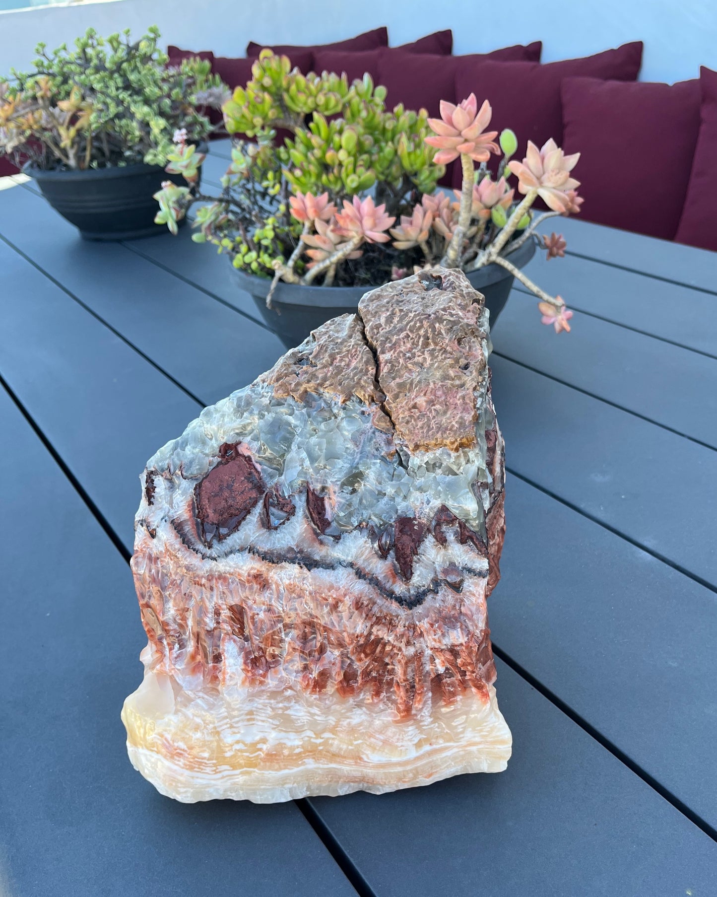Decorative tri color crystal on a table with potted plants in the background
