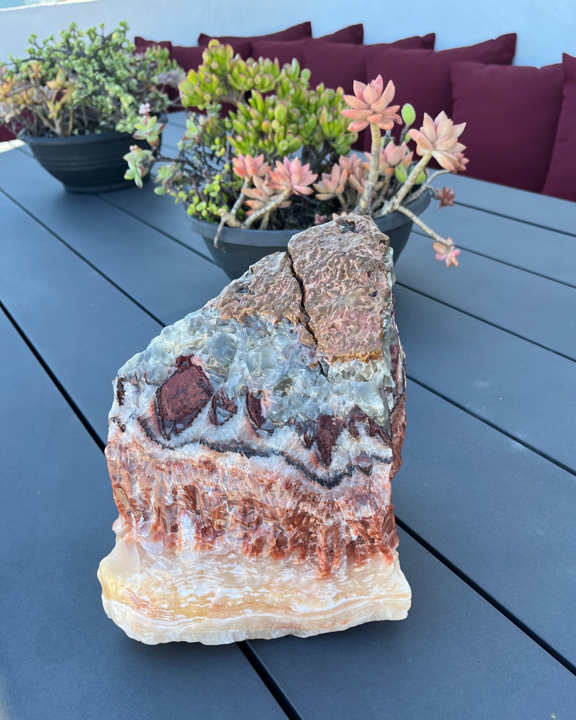 Decorative tri color crystal on a table with potted plants in the background