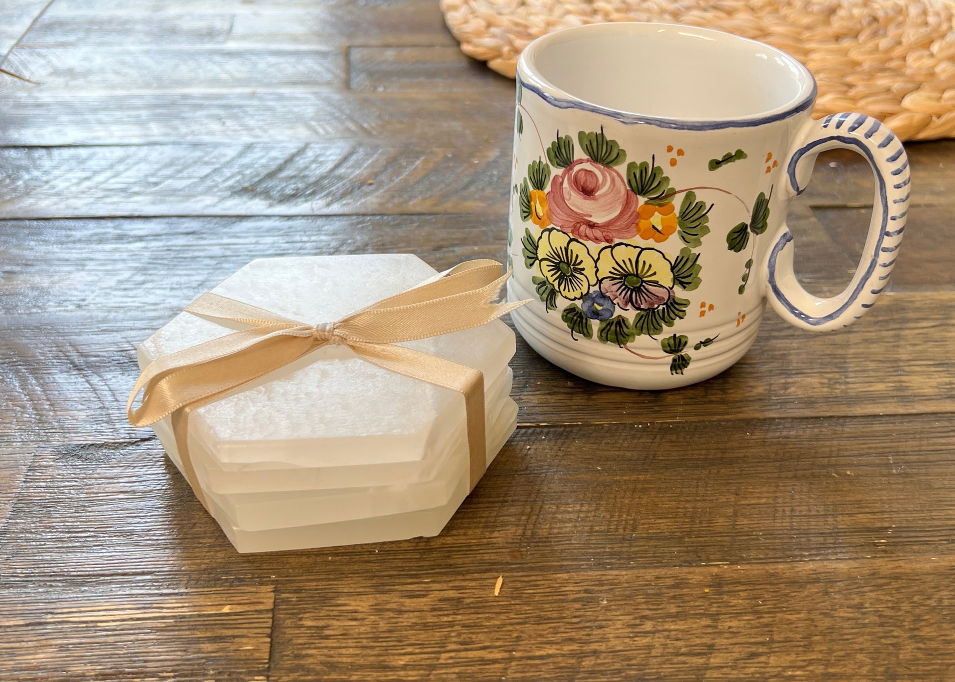 set of 4 white hexagonal shaped coasters with flowery mug on wood table