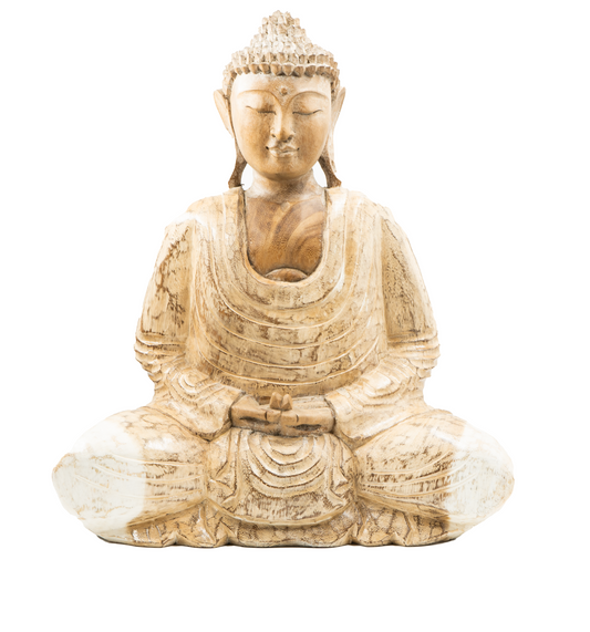 A wooden statue of the Buddha sitting in a meditative pose with a whitewash finish.